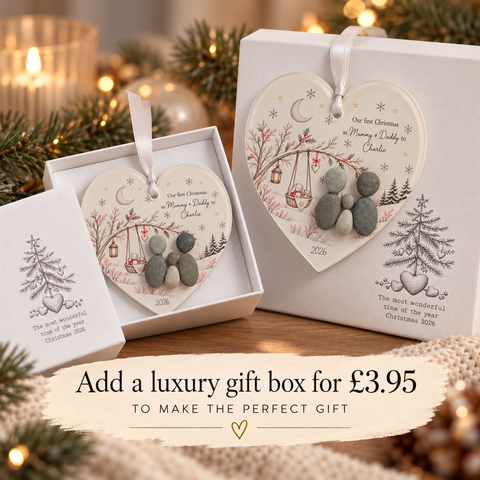 Our First Christmas pebble decoration shown with the optional Christmas 2026 luxury gift box