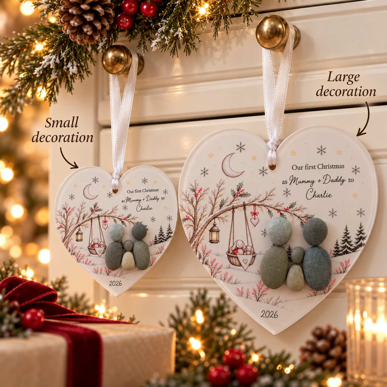 Small and large Our First Christmas pebble heart decorations side by side to show the two sizes