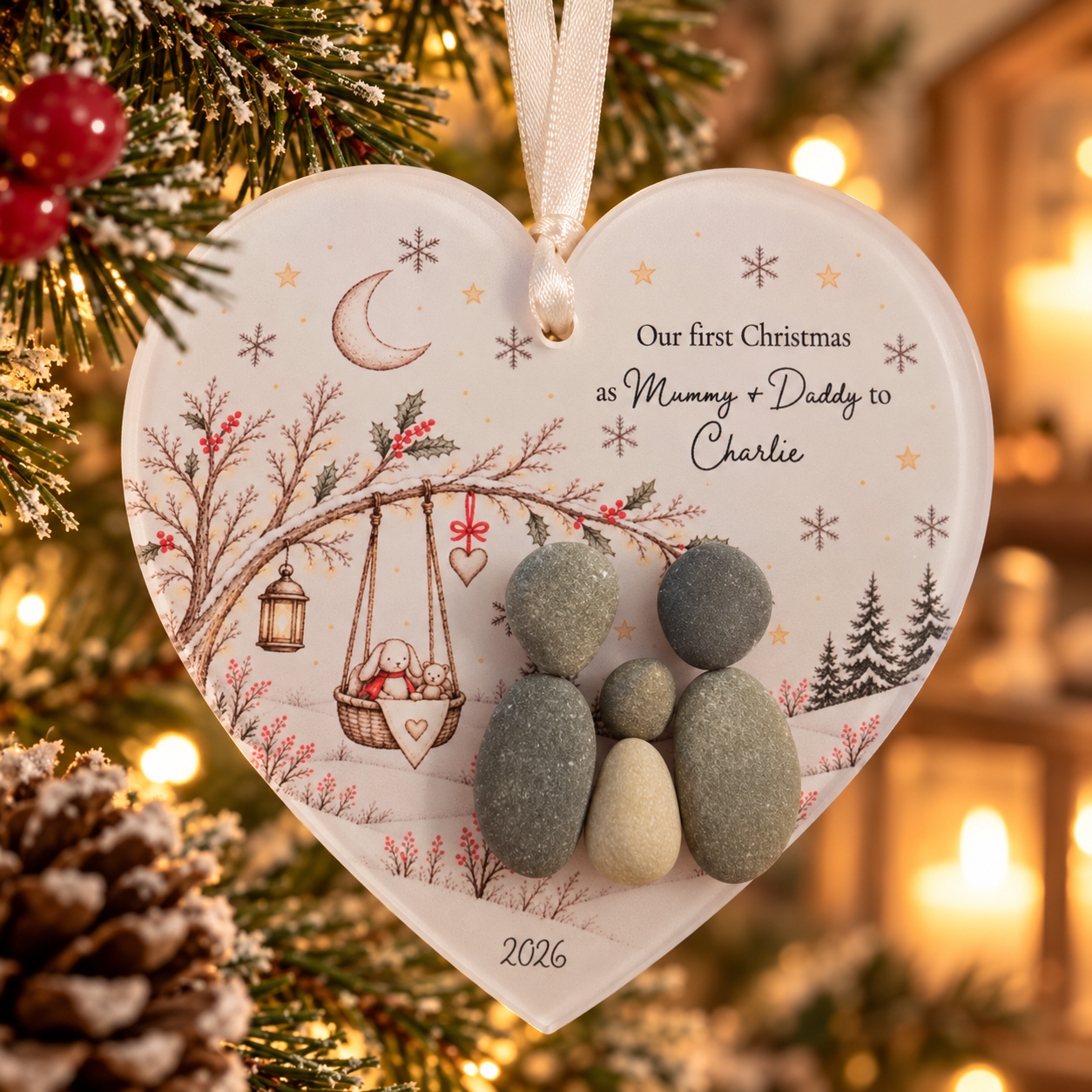 Our First Christmas as Mummy + Daddy to Charlie pebble heart decoration hanging on a snowy Christmas tree