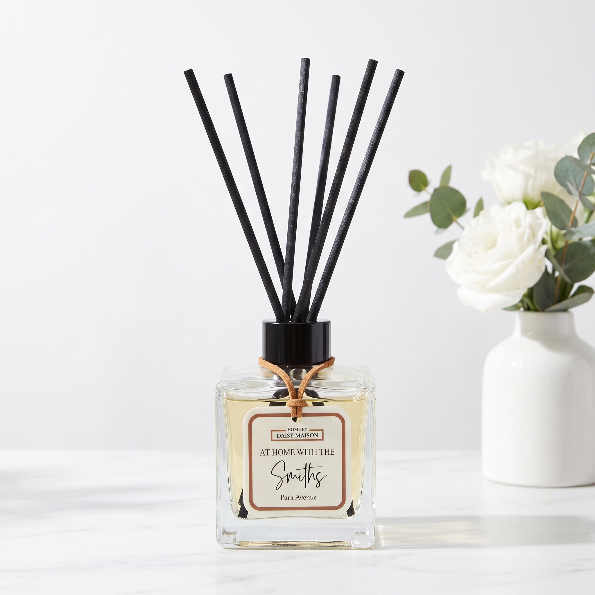 Personalised family reed diffuser styled on white marble with white roses and eucalyptus