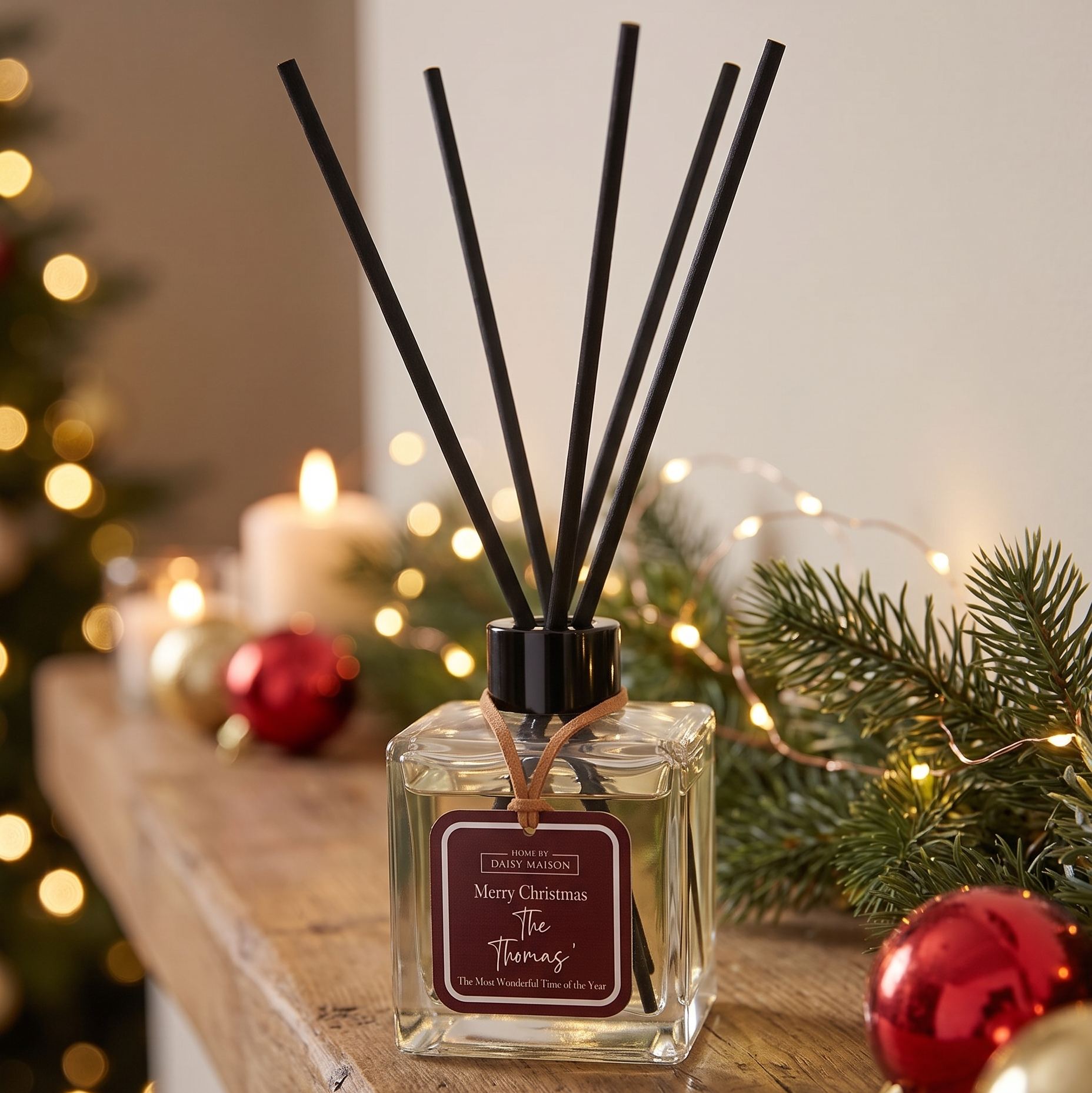 Personalised Christmas reed diffuser, Merry Christmas The Thomas', on a festive mantel with fairy lights
