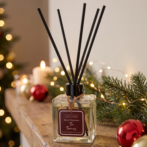 Personalised Christmas reed diffuser, Merry Christmas The Thomas', on a festive mantel with fairy lights