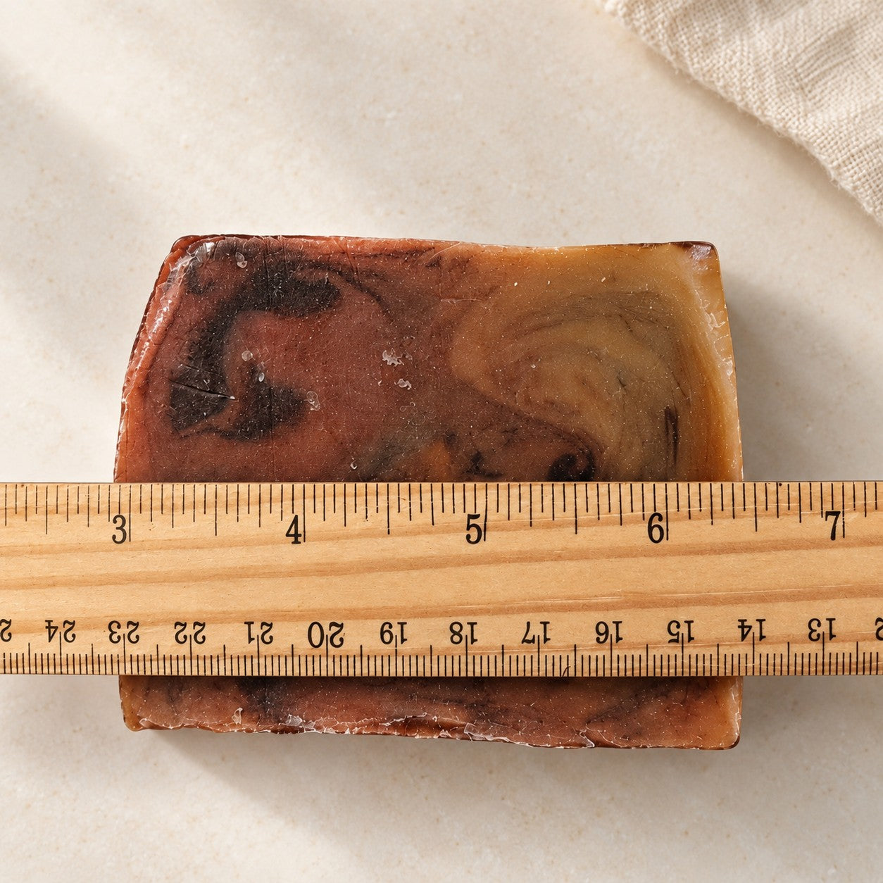 Emerald Truffle soap slice next to a ruler to show its size
