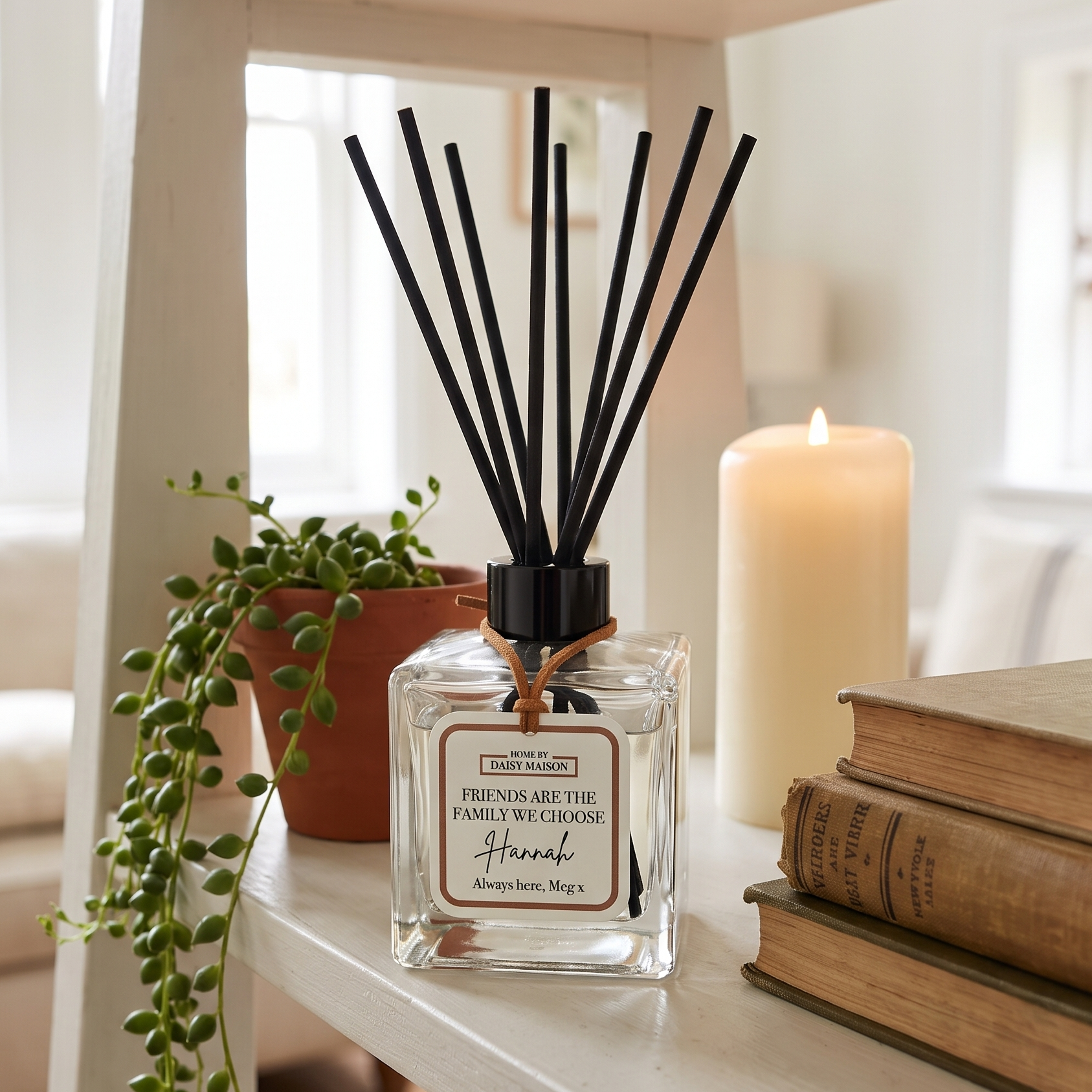 Personalised friendship reed diffuser on a warm styled shelf with a trailing plant and candle, Friends Are The Family We Choose, Hannah