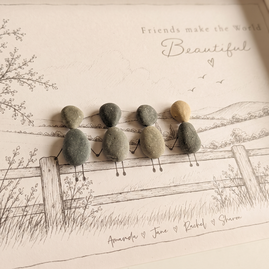 Close-up of four pebble friends holding hands on a sketched fence with their names written underneath