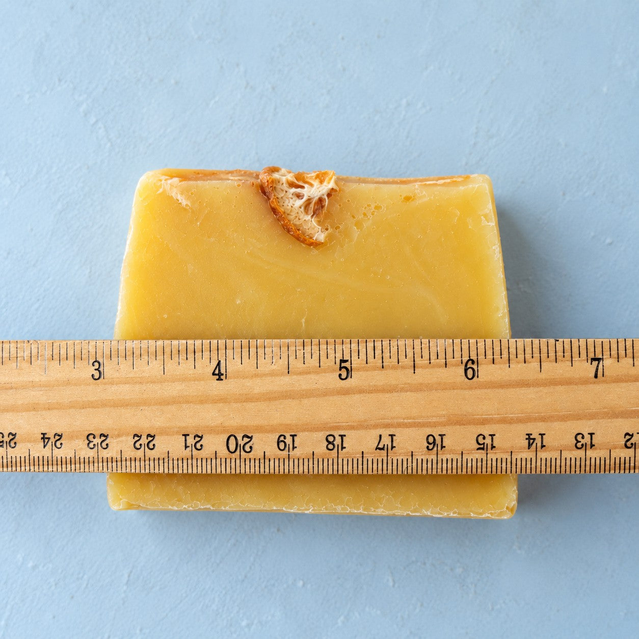 Slice of Sunshine soap slice next to a ruler to show its size