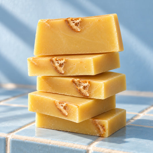 Stack of yellow Slice of Sunshine soap slices with dried orange