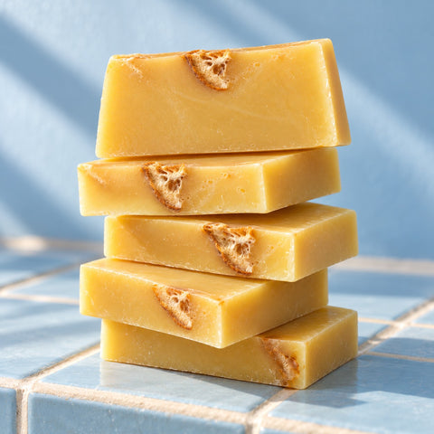 Stack of yellow Slice of Sunshine soap slices with dried orange